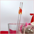 Straw with three autumninal leaves in a glass