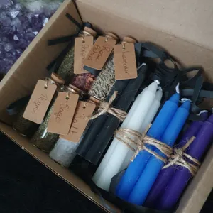 Supply kit containing spell candles, in hand wrapped bundles of 3, and 6 ingredient jars with handmade labels. Candle bundles include black, white, blue and purple. Ingredients contain a jar each of rosemary, thyme, salt, rose petals, peppermint and sage.
