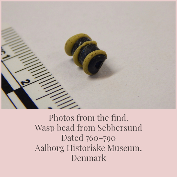 Museam photo of the find showing the barrel like bead with raised yellow lines