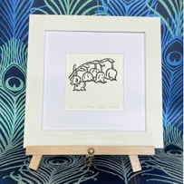 Lily of the Valley framed in white on a beech easel against a peacock background