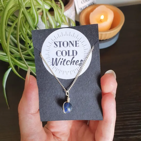 Small lapis lazuli sphere bound in a simple wire wrap onto silver chain