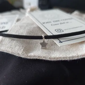 Tiny silver star charm hooked onto black suede choker