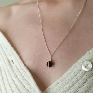 Small black onyx sphere bound in a simple wire wrap onto silver chain