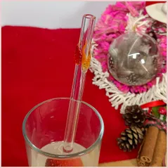 Straw with three autumninal leaves in a glass