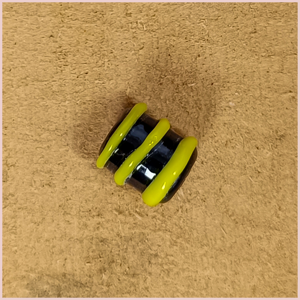 Subbersund Wasp Bead. A black bead with three raised lines of yellow close up detail