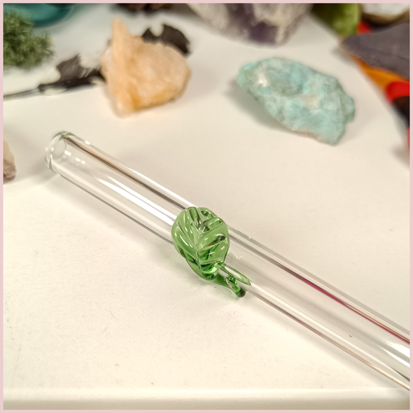 Close up of a handmade glass straw with a leaf design