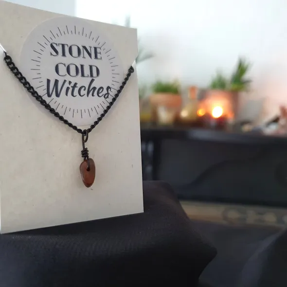 Small tigers eye polished crystal on a black chain, bound using a simple black wire wrap