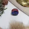 A photo of the bead on a white background but slightly framed with items associated with the viking era