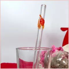 Straw with three autumninal leaves in a glass