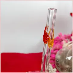 Straw with three autumninal leaves in a glass