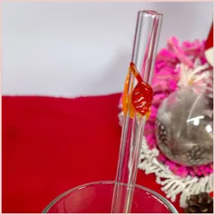 Straw with three autumninal leaves in a glass