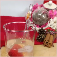 Straw with three autumninal leaves in a glass