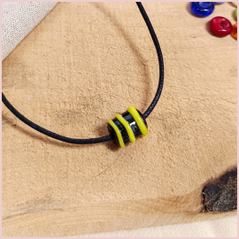 Subbersund Wasp Bead. A black bead with three raised lines of yellow shown on a cord