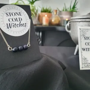 3x small blue goldstone crystals gathered in a line, on a horizontal silver wire  connected onto a dainty silver chain via looped ends