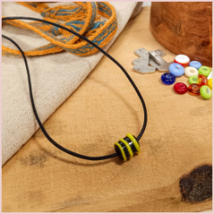 Subbersund Wasp Bead. A black bead with three raised lines of yellow shown on a cord