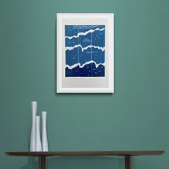 Blue White and Teal Waves Print in Framed in White on a Blue Wall Above Dark Shelf and Vase Set