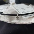 Tiny silver star charm hooked onto black suede choker