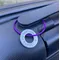 1 inch aluminium washer stamped with the words living my best life.  the washer hangs on a purple wire loop to make a luggage tag.  the item is shown attached to the handle of a suitcase