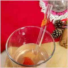 Straw with three autumninal leaves in a glass