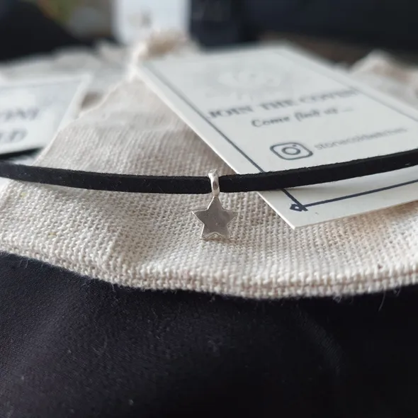 Tiny silver star charm hooked onto black suede choker