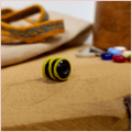 Subbersund Wasp Bead. A black bead with three raised lines of yellow photo taken from the side