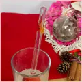 Straw with three autumninal leaves in a glass
