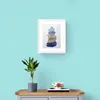 Blue Yellow and Silver Pebbles Stack Print in Framed in White on a Blue Wall Above a Wooden Drawer Unit